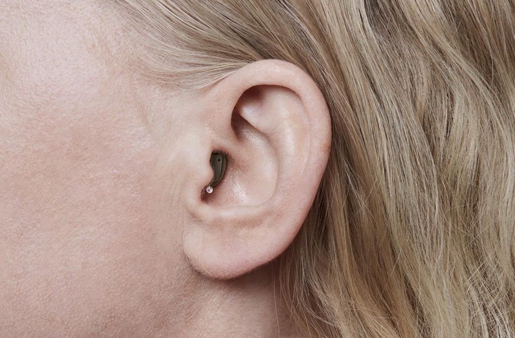 mulher usando aparelho auditivo invisível